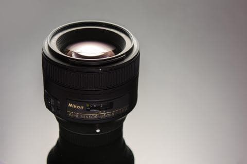 這張照片是一個尼康鏡頭，鏡頭上有 AF-S NIKKOR 85mm 1:1.8G 字樣。