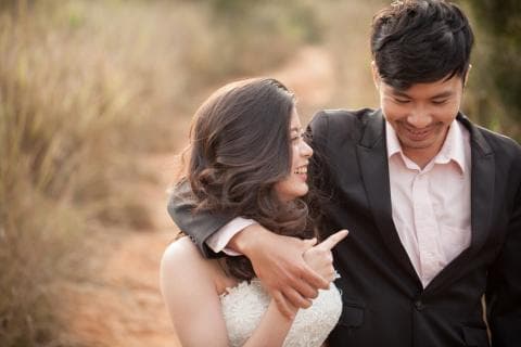 這張照片是一對情侶在戶外擁抱，男方從背後擁抱女方，女方臉上帶著幸福的笑容，兩人看起來非常甜蜜。