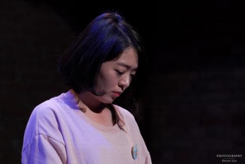 這張「一位年輕女性穿著粉紅色上衣，低頭沉思」的照片是。