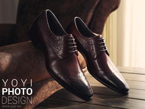 這張「兩雙皮鞋」的照片是兩雙深棕色的皮鞋，鞋面有雕花，放在棕色皮革上。