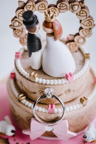 這張照片是一對新人在蛋糕上的結婚戒指。戒指閃閃發光，顯得非常耀眼。