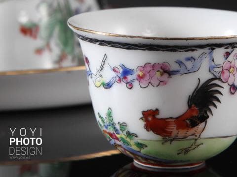 這張「茶杯」的照片是一隻紅色公雞圖案的陶瓷杯，杯子上還畫著一些花卉和鳥類。