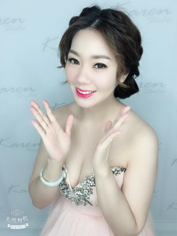 這張「新娘」的照片是一個年輕女子，她穿著一件粉色的禮服，並且戴著一條手鐲。她正在擺姿勢，露出她的笑容。她的頭髮被編成了辮子，看起來非常漂亮。