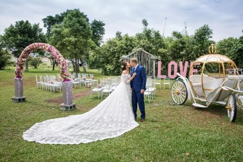 這張照片是婚禮現場，最重要的是新娘和新郎正在親吻，背景是美麗的草坪和花朵。