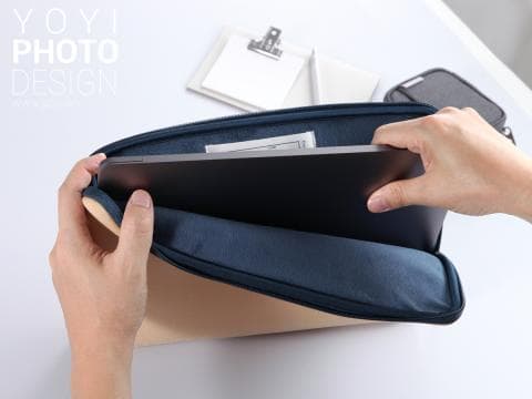 這張照片是一個藍色的筆記本電腦保護套，裡面放著一臺筆記本電腦。保護套的材質柔軟，設計簡約，看起來很耐用。