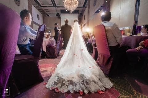 這張照片是一對新人正在舉行婚禮，新娘穿著一件美麗的婚紗，正在接受親友的祝福。