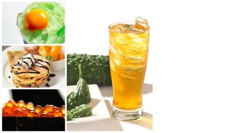 這張照片是一杯冰涼的黃色飲料，裝在玻璃杯中，杯口有冰塊。飲料看起來很清涼爽口，讓人想喝一口。