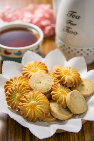 這張照片是一盤美味的餅乾，上面放著各種口味和形狀的餅乾，包括有花朵形狀的、圓形的、還有經典的餅乾，看起來非常可口。