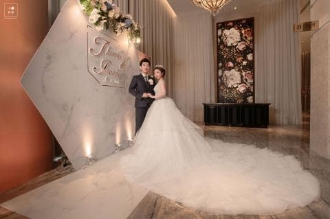 這張照片是一對新人正在結婚典禮上，新娘穿著美麗的婚紗，新郎則穿著西裝，他們看起來非常幸福。