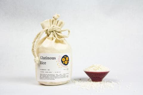 這張「糯米」的照片是一包用布袋包裝的糯米，旁邊有一碗糯米和一些散落的糯米。