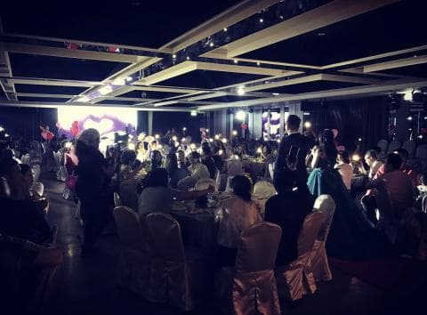 這張照片是一場婚禮宴會，照片中最多的人正在舉辦婚禮，他們都穿著正式的衣服，並且看起來很開心。