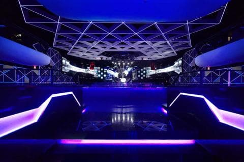 這張照片是一個夜晚的夜店，最重要的是舞池，舞池上裝飾著明亮的燈光和炫目的燈光效果，營造出熱烈狂歡的氛圍。