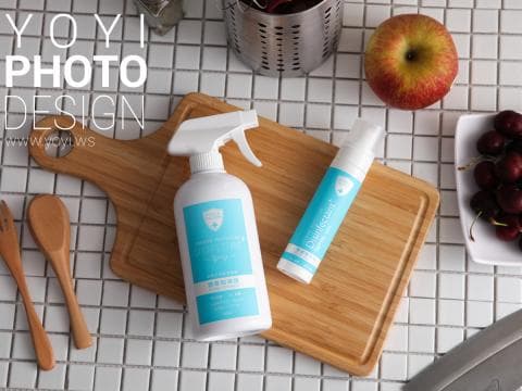 這張「產品」的照片是一個木製切菜板，上面放著兩瓶清潔劑和一個蘋果。