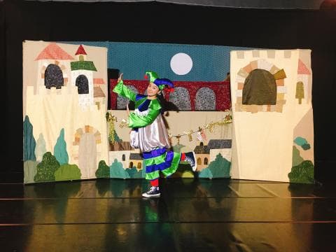 這張照片是一個舞台，舞台上有一個穿著戲服的女生，她正在表演。