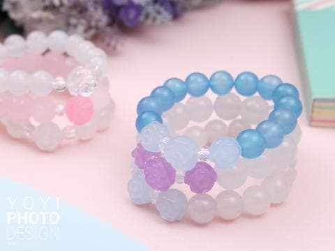 這張「手鍊」的照片是三條不同顏色的手鍊，分別是藍色、白色和粉紅色，它們都帶有花朵形狀的裝飾。