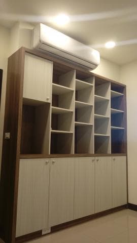 這張照片是一個木質的收納櫃，它有許多層架，以及幾個木門。櫃子設計簡潔大方，可以收納許多物品，非常實用。