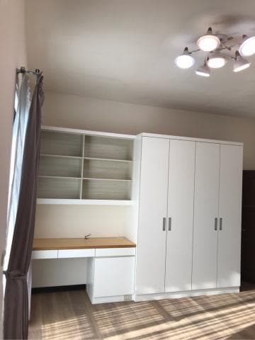 這張照片是一個簡約的書房，其中最重要的是一個白色書桌和一個白色書櫃。書桌上有木質桌面，方便閱讀或寫作，而書櫃則可以存放書籍和其他物品，保持書房的整潔和井然有序。