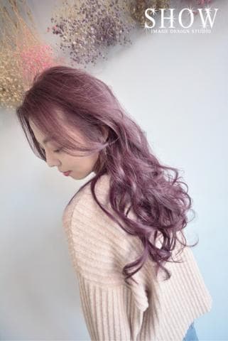 這張「女生髮型」的照片是一個女生留著一頭浪漫的捲髮，髮色是淡淡的紫色。