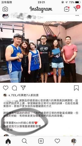 這張照片是  一個健身房的照片，照片中一群人圍在一起，其中一個人指著一個愛心，表示對健身教練的感謝。