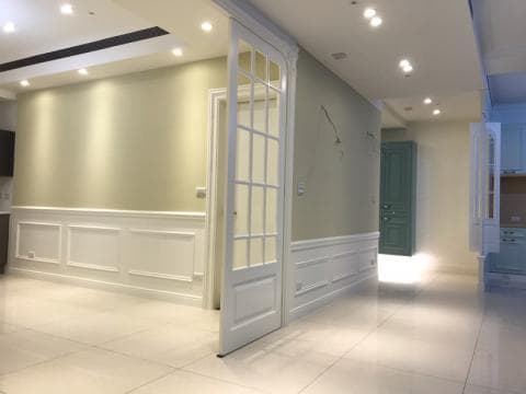 這張照片是一間房間的角落，牆上裝飾著白色的護牆板，有著典雅的線條，突顯出房間的精緻風格。