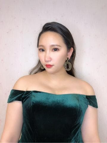 這張「女子穿著綠色天鵝絨禮服」的照片是，她看起來很優雅，戴著金色的耳環。