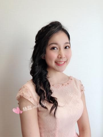 這張「婚紗照」的照片是一位身穿粉紅色蕾絲禮服的女生，她留著一頭黑色長髮，並搭配精緻的妝容。