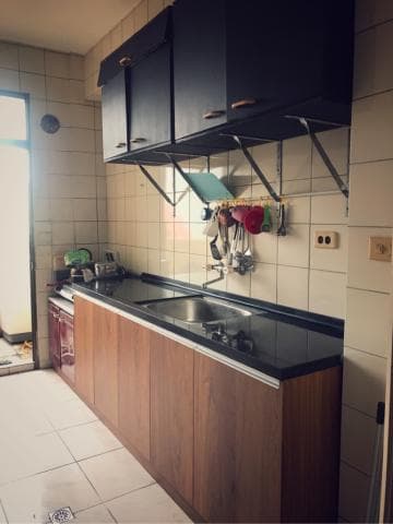 這張照片是一個廚房，最重要的是木頭材質的流理台，上面放著黑色的流理台面和水槽。