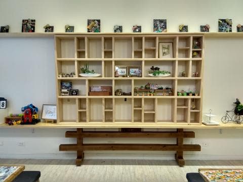 這張照片是一個木製的層架，上面擺放著許多裝飾品和盆栽。層架的設計簡單大方，木質紋理自然，散發著溫馨舒適的氛圍。