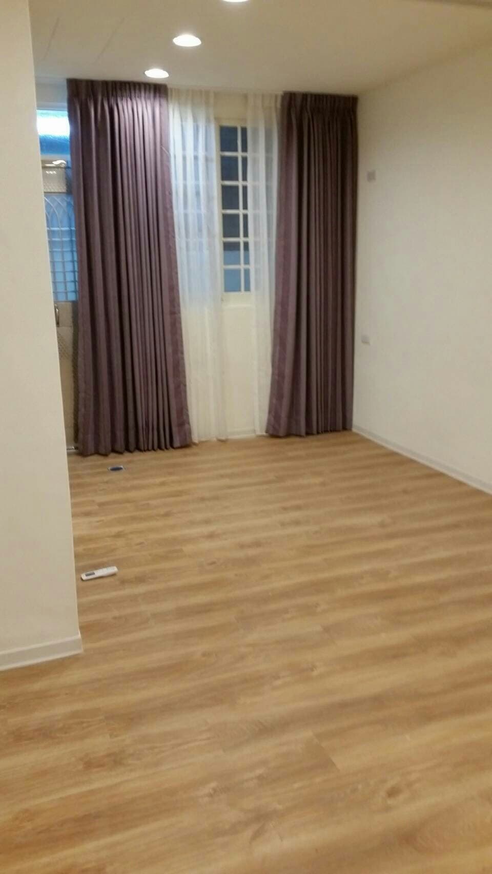 這張照片是一間房間的木地板，木地板的顏色是淺棕色，看起來很新。