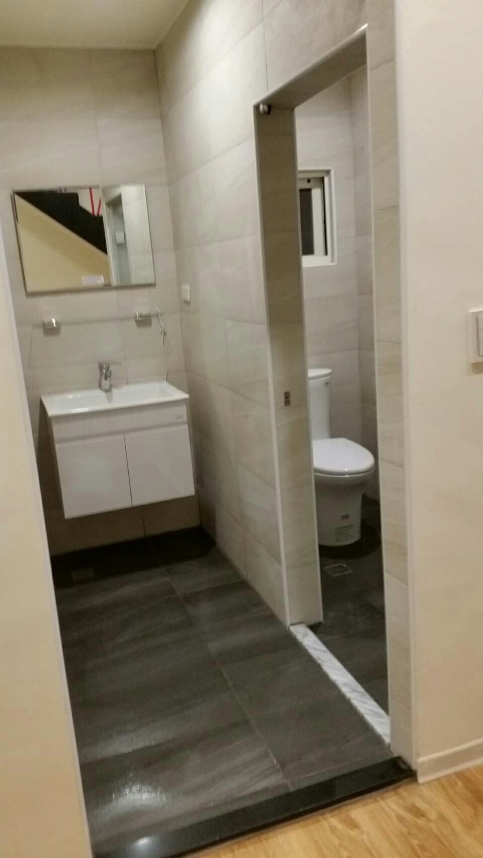 這張照片是一個現代化的浴室，主要重點是浴室的瓷磚地板，看起來非常乾淨和時尚。