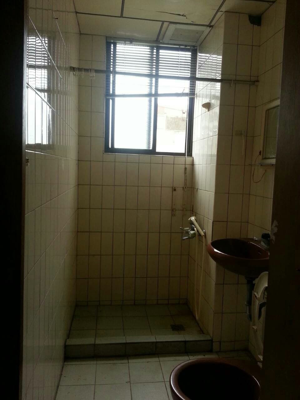 1) 照片顯示一個浴室，裡面的空間比較狹小，只有淋浴間和一個馬桶