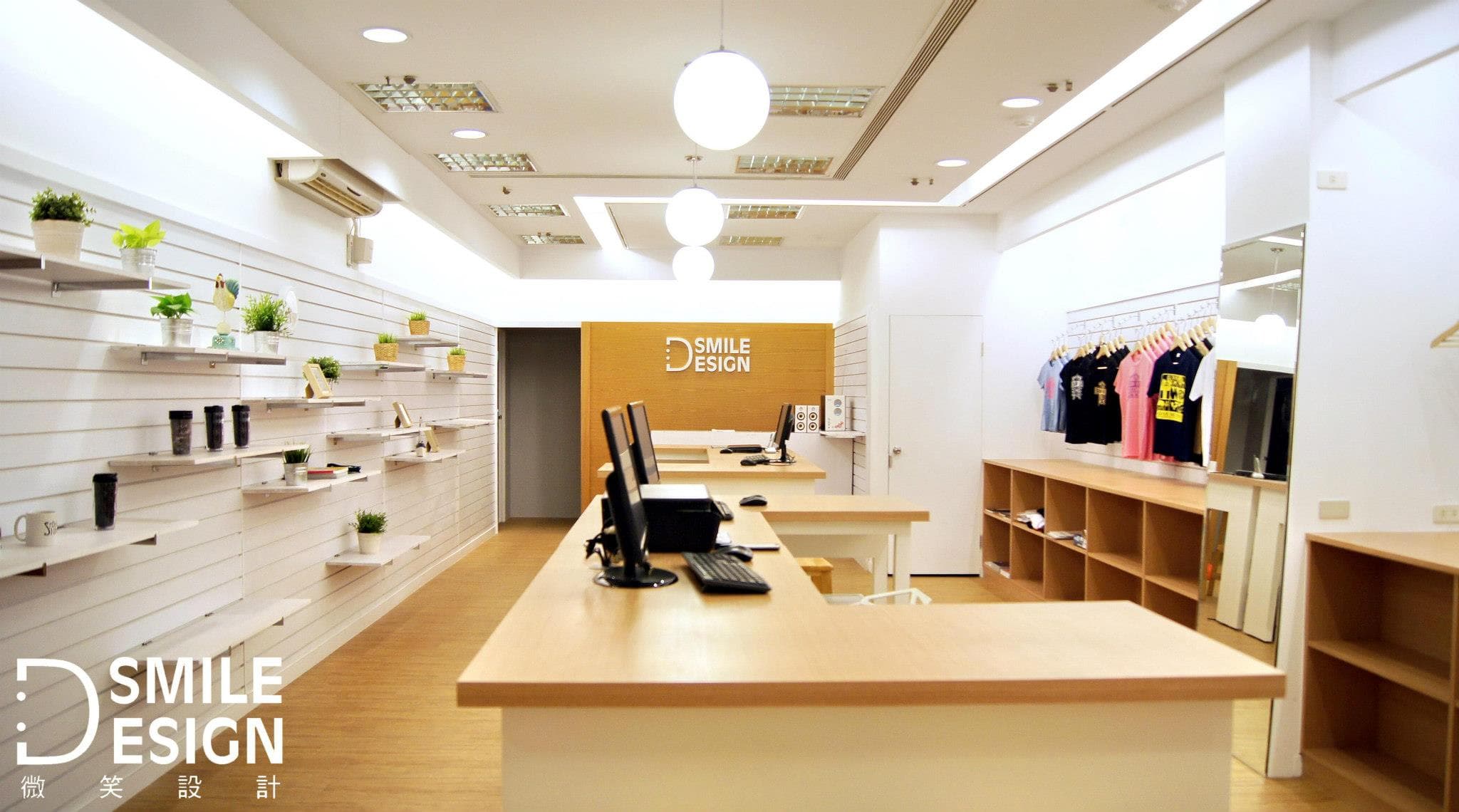 這張照片是一間簡約風格的服飾店，最重要的是店內左側牆壁上排列整齊的白色層架，上面擺放著商品，營造出乾淨整潔的視覺效果，突顯店家的設計理念。