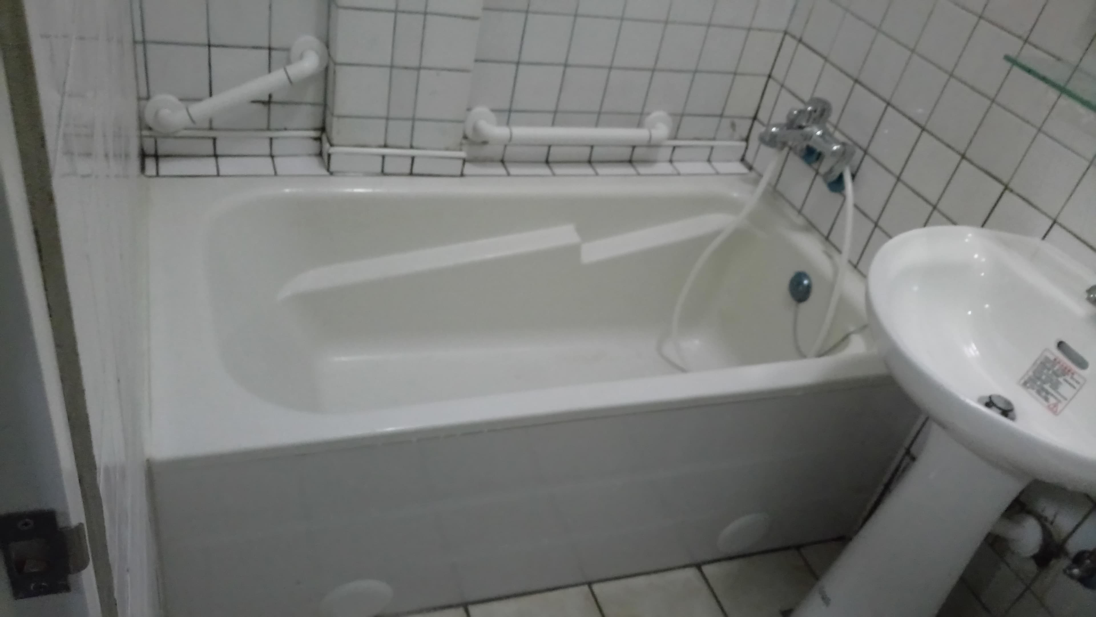 1) 照片顯示一個白色浴缸，旁邊有一個白色洗手台