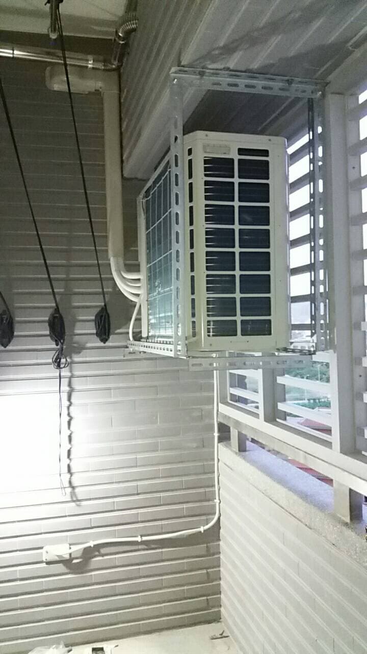 1) 照片顯示一個裝在磚牆上的室外冷氣機組