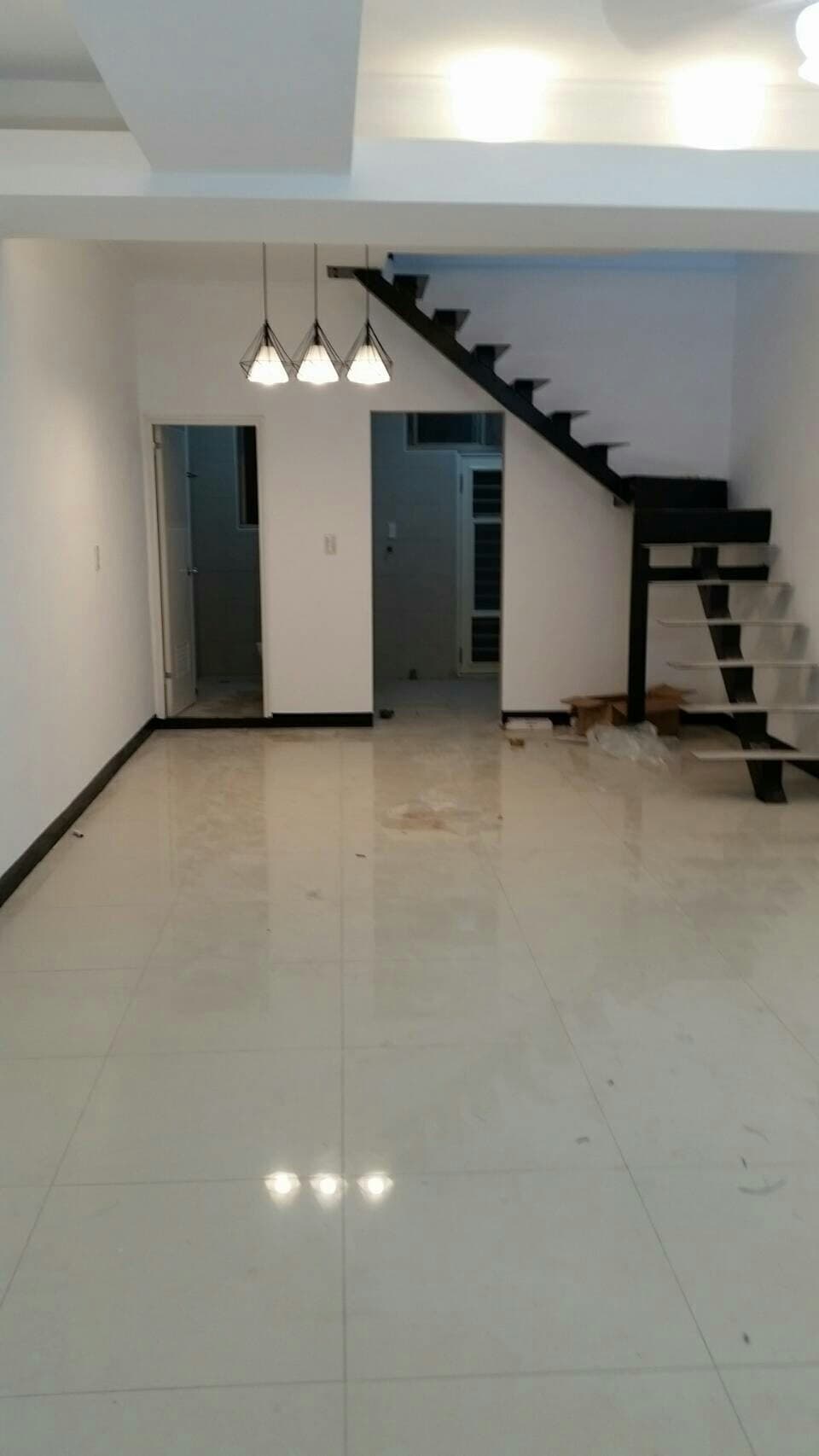 這張照片是 一個現代化的客廳，地板是白色拋光磚，光線明亮，感覺非常舒適。