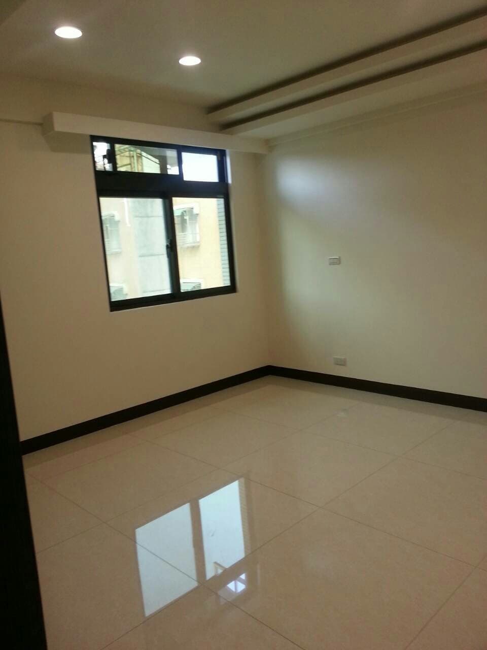 這張照片是一個明亮的房間，房間裡鋪設了光滑的白色磁磚地板，光線從窗戶照射進來，讓地板反射出明亮的光芒。