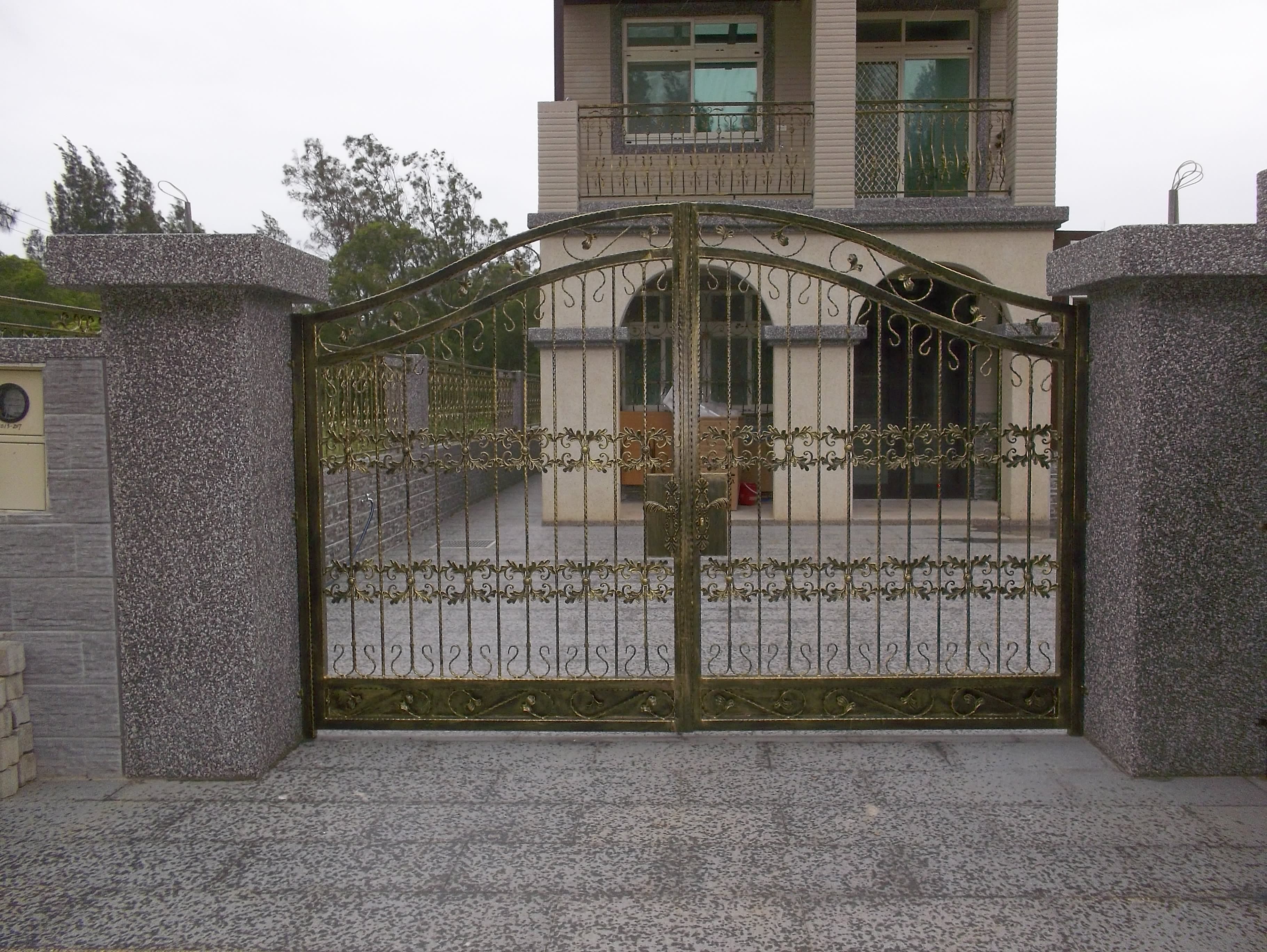 1) 照片顯示一個帶有鐵柵欄的住宅建築物