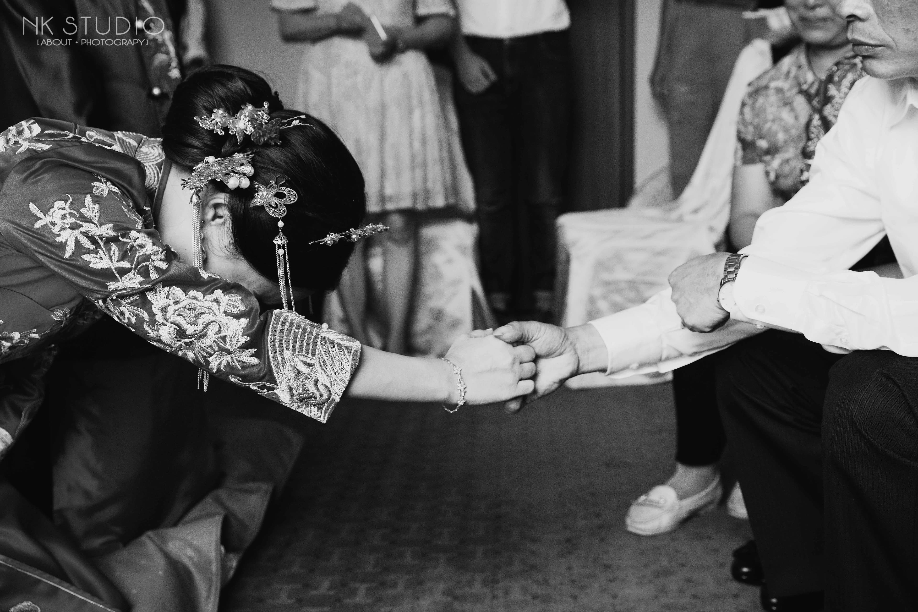 這張照片是一個傳統婚禮的儀式，新娘正向一位年長的男性長輩行跪拜禮。