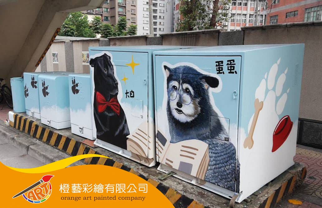 這張「狗」的照片是三個畫著不同狗的箱子。左邊的狗戴著紅色領結，中間的狗戴著眼鏡，右邊的狗戴著藍色的圍巾。