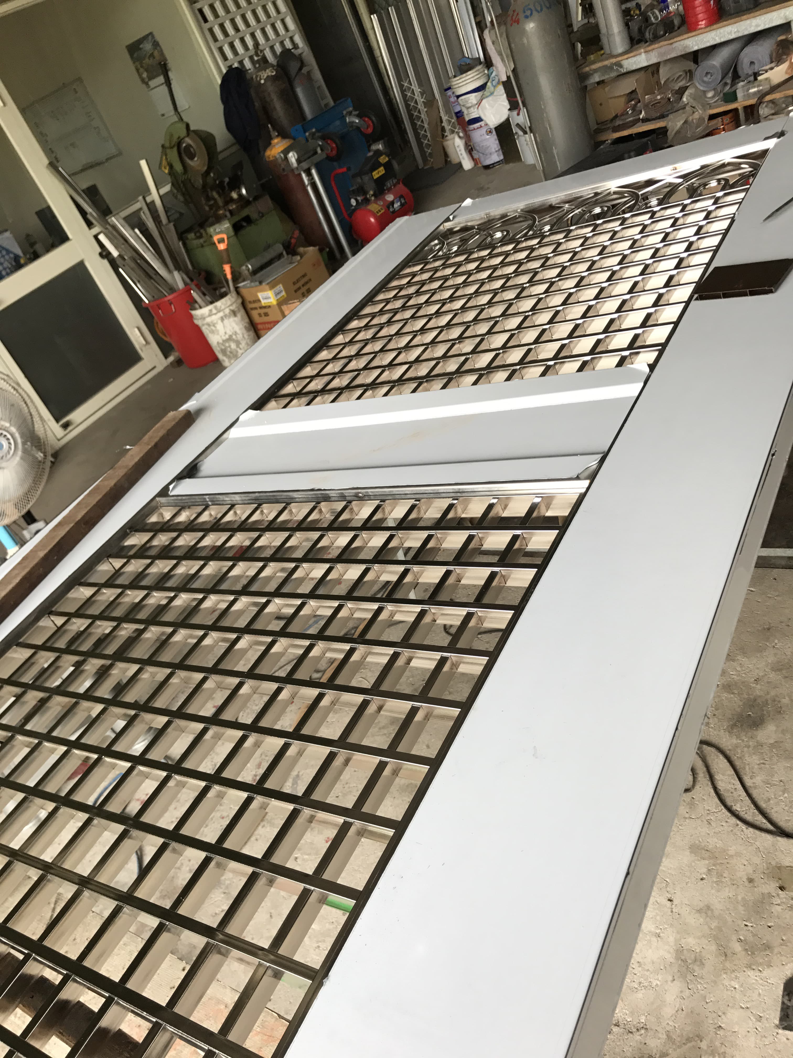 1) 照片顯示了一個金屬格柵門，門上有著方格狀的設計，看起來很堅固