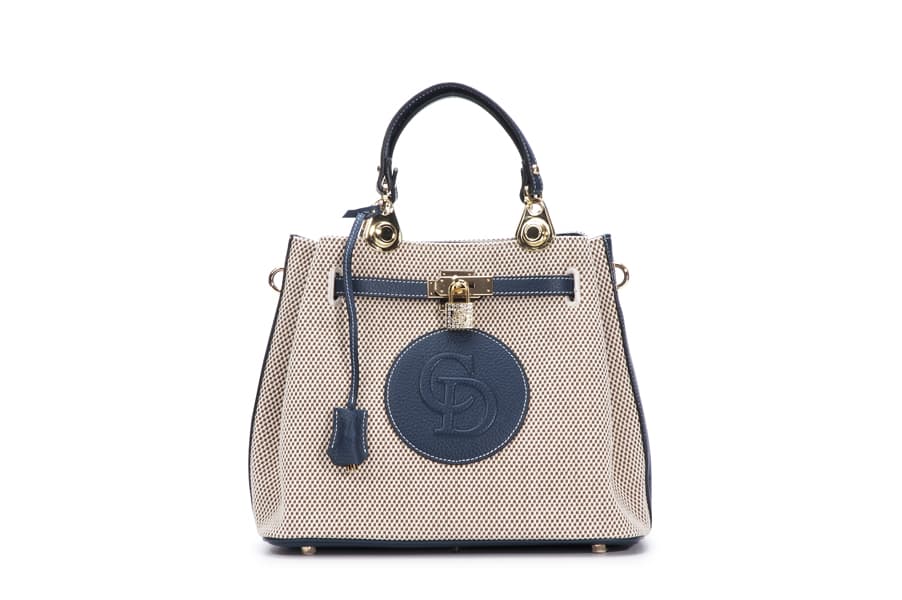 這張「手提包」的照片是一個藍色和米色的手提包，上面有一個金色的鎖和一個圓形的品牌標誌。
