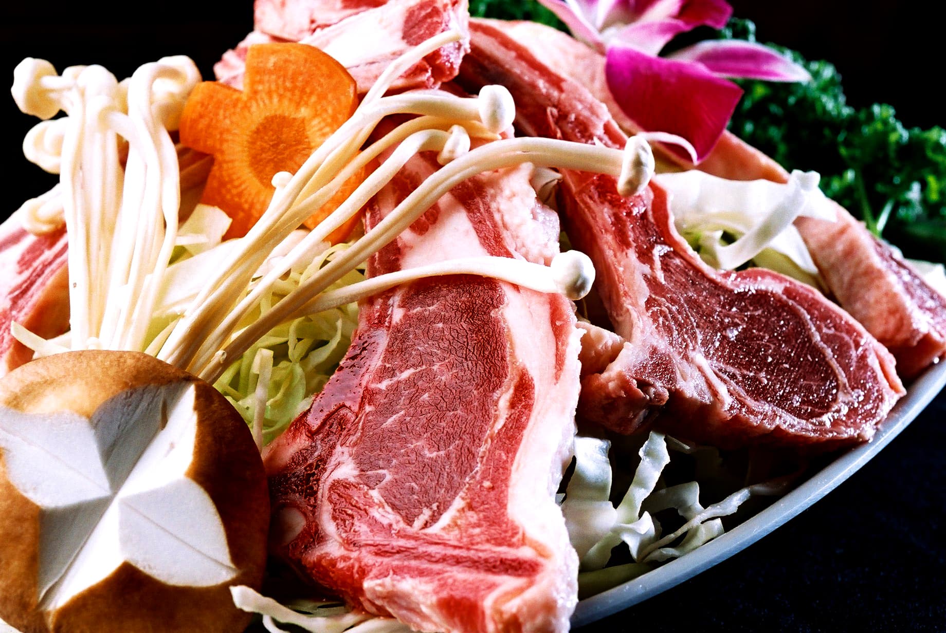 這張照片是一盤烤肉，上面有香菇、洋蔥和一些蔬菜。烤肉看起來很美味，肉質鮮美，令人食指大動。