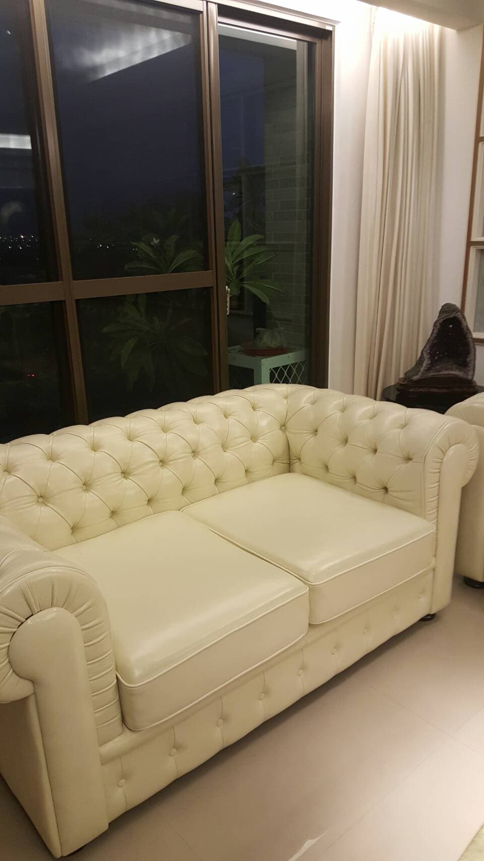 1) 照片顯示一個白色皮革沙發,有鈕釦裝飾