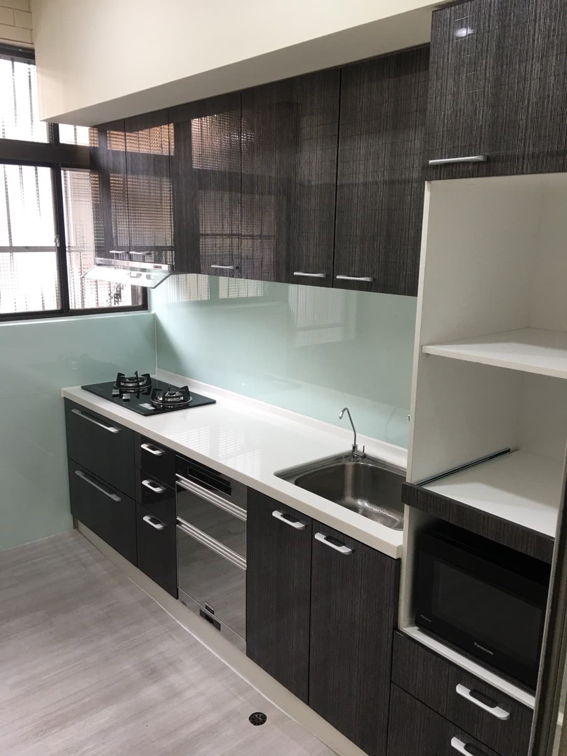 這張照片是現代化的廚房,最重要的是木紋櫥櫃,採用深色木紋,顯得高檔且有質感。