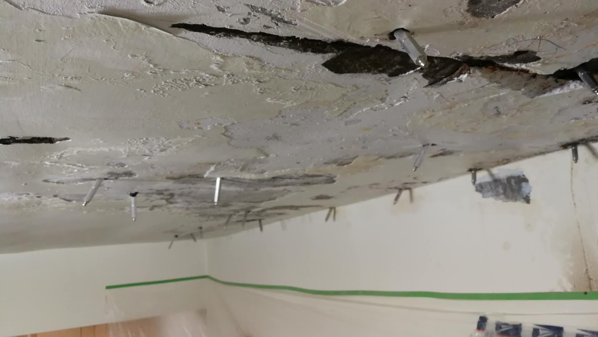 1) 照片顯示一個天花板，天花板有許多裂縫，有些地方看起來像剝落