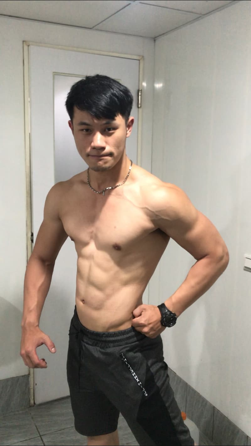 這張照片是一個年輕男子，他擁有健壯的肌肉，並且露出他結實的腹肌。