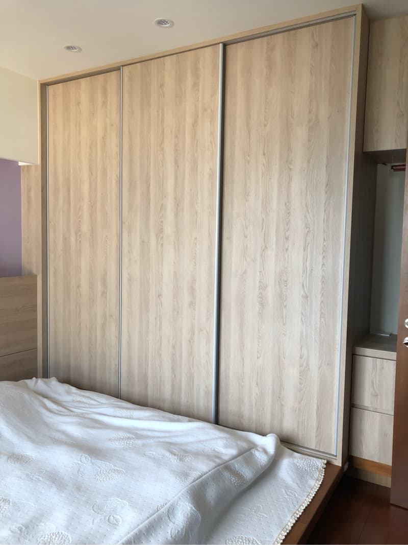 這張照片是臥室裡的大衣櫃，櫃門是木紋的滑門，看起來很美觀，而且很實用。