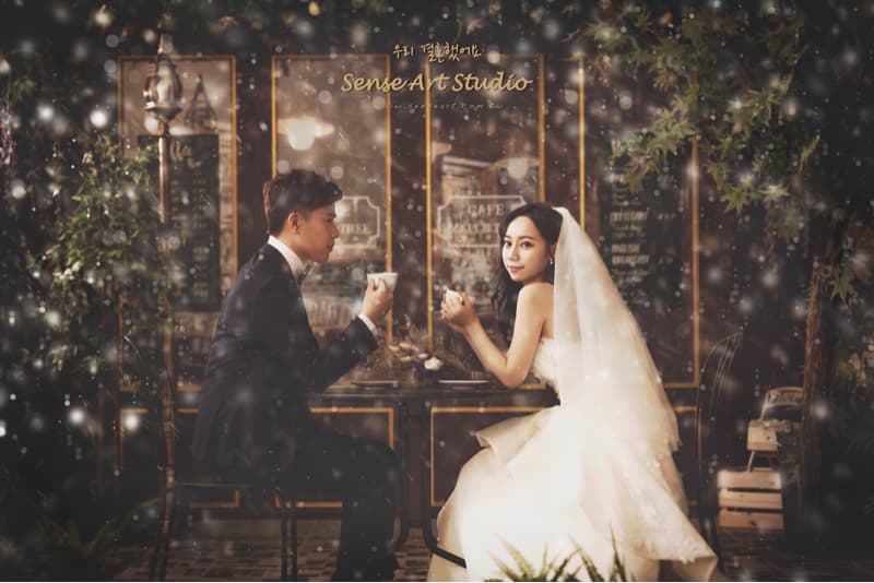 這張照片是一對新人在咖啡廳裡喝下午茶，背景是浪漫的冬季氛圍。
