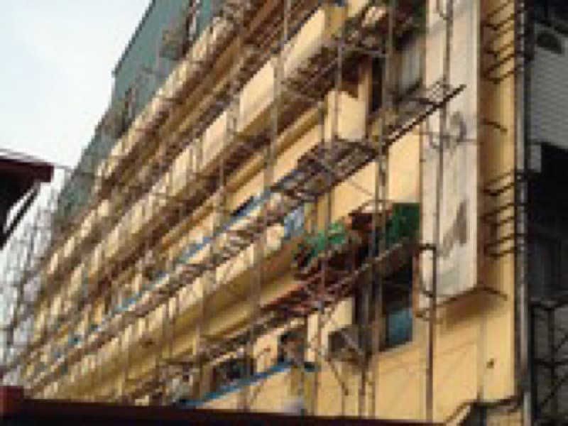 1) 照片顯示了一棟建築物，建築物外牆覆蓋著鷹架
