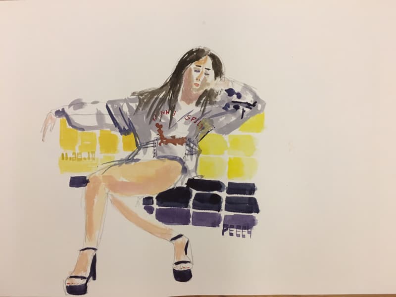 這張照片是一個女子坐在黃色和黑色格子上的水彩畫。女子穿著灰色上衣，紅色字母，頭向後仰，一隻手放在臉上，另一隻手撐著椅背。女子有一頭長髮，畫家用黑色的線條勾勒出她的輪廓。